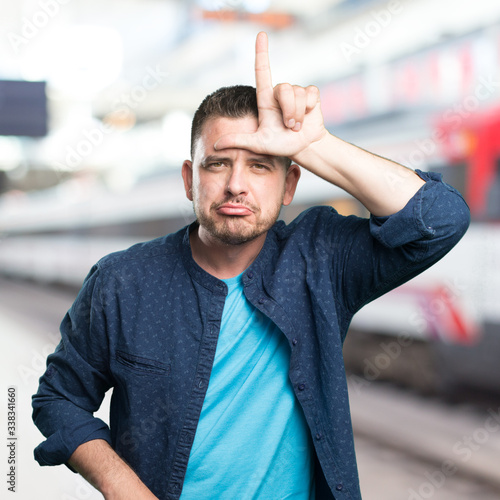 Young man wearing a blue outfit. Doing looser gesture. © borjandreu