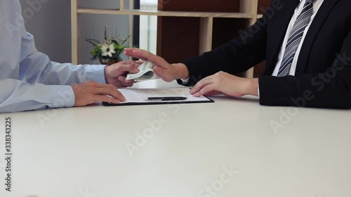 The operator employee submits documents and money to the manager while the manager denies the bribe.