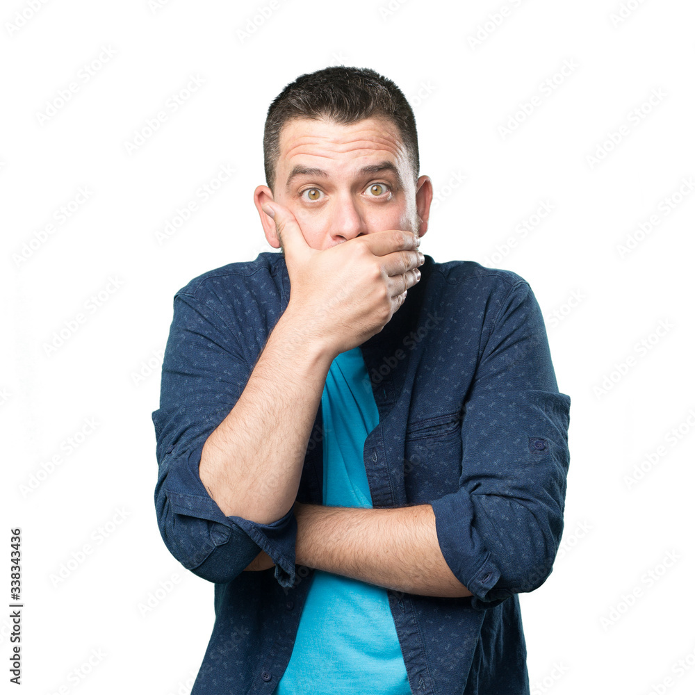 Young man wearing a blue outfit. Looking surpresided and covering his mouth with his hand. Young man wearing a blue outfit. Looking surpresided and covering his mouth with his hand.