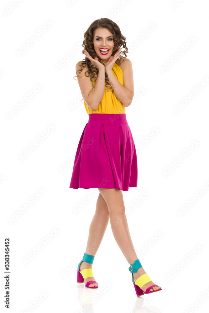 Young Woman In Vibrant Clothes Is Walking And Holding Head In Hands