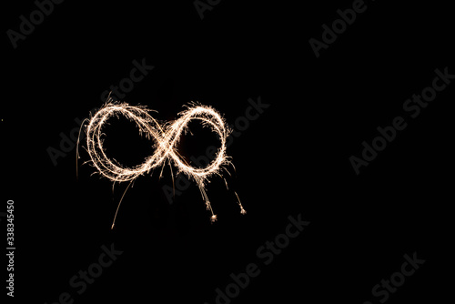 handwritten infinite loop, light painting experiment with bulb exposure, at night. black background