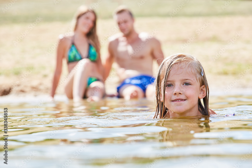 Fototapeta premium Kleines Mädchen lernt Schwimmen im Badesee