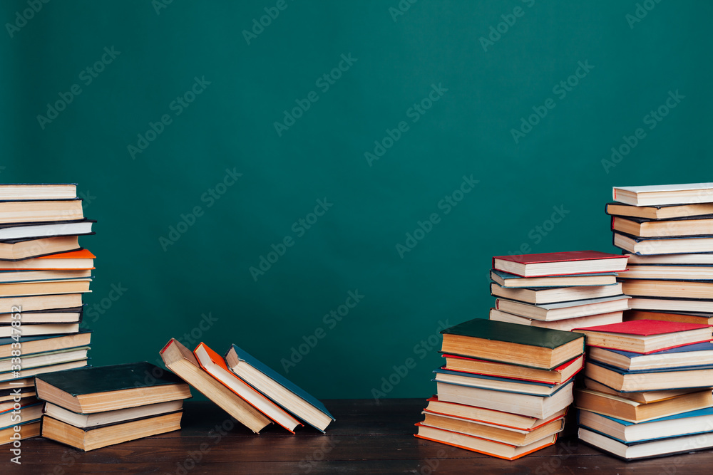 many stacks of educational books to teach in the school library on a green background many stacks of educational books to teach in the school library on a green background