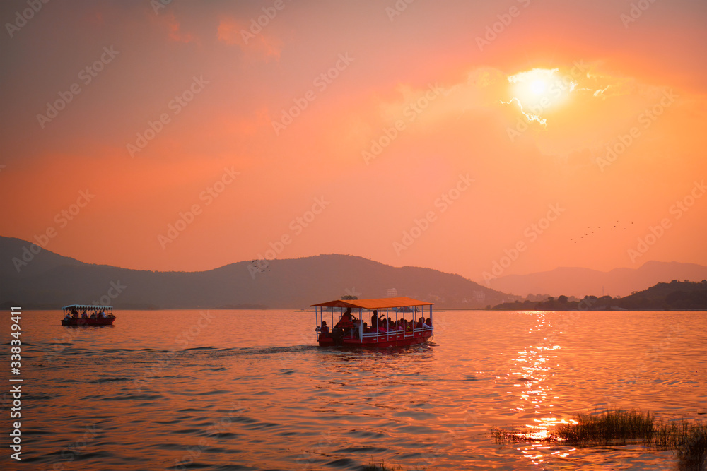 Tourist boat in lake Pichola on sunset. Udaipur, Rajasthan, India