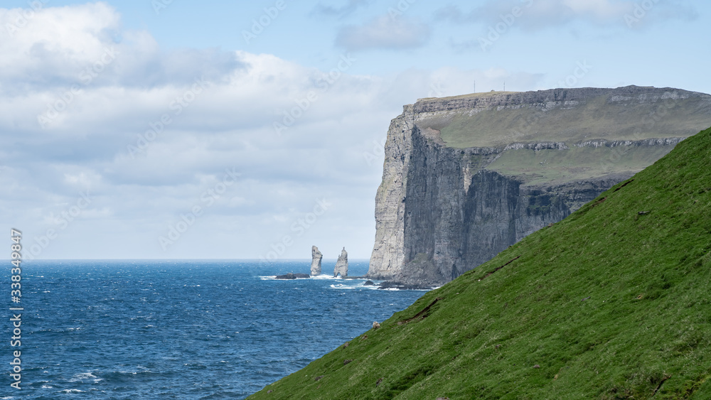 Risin and Kellingin rocks as seen from Tjornuvik bay with waves hitting the shore on Streymoy on the Faroe Islands, Denmark, Europe