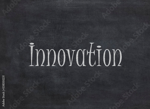 innovation word in white chalk handwriting on blackboard