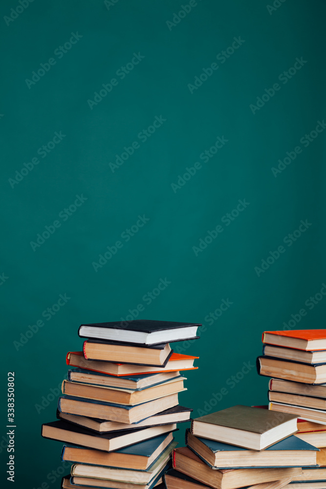 many stacks of educational books to teach in the school library on a green background many stacks of educational books to teach in the school library on a green background