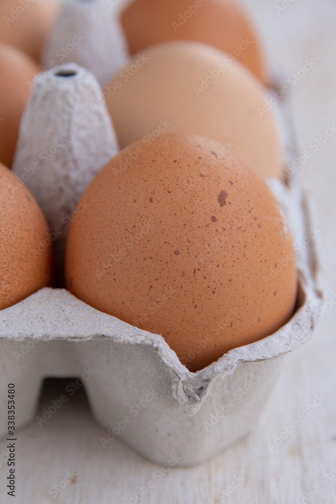 Cardboard egg tray with eggs on white wooden table Cardboard egg tray with eggs on white wooden table