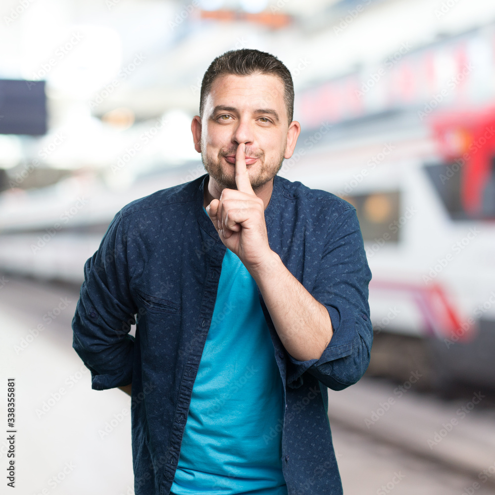 Naklejka premium Young man wearing a blue outfit. Doing silence gesture.