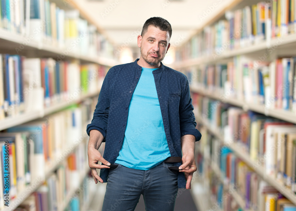 Young man wearing a blue outfit. Doing money less gesture.