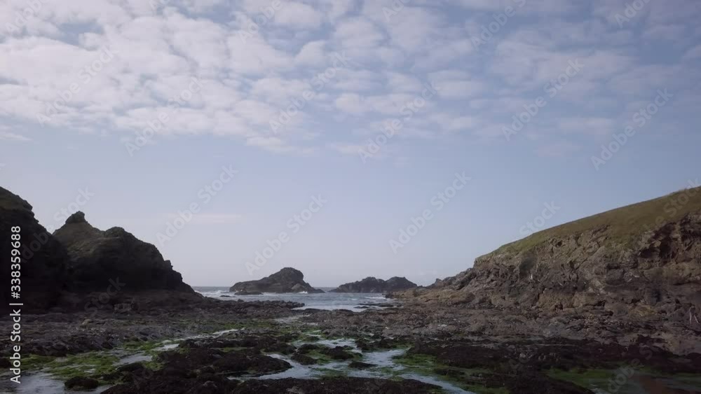 Aerial drone shot pushing in towards rock formation in sea, birds swim across screen, Cornwall, England, UK Aerial drone shot pushing in towards rock formation in sea, birds swim across screen, Cornwall, England, UK