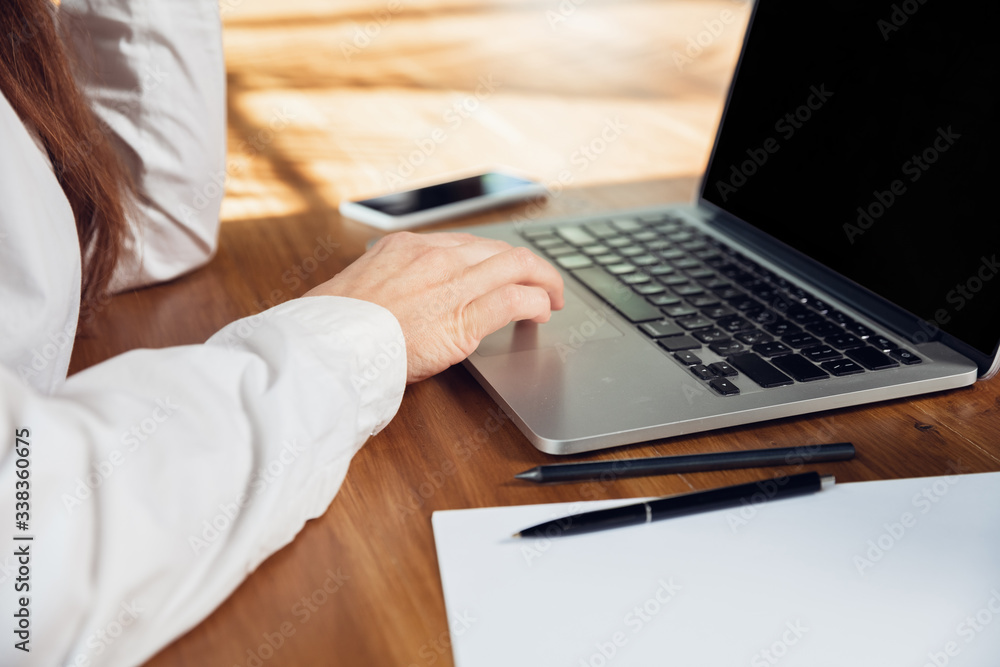Typing text. Close up. Caucasian young woman in business attire working in office. Young businesswoman, manager doing tasks with smartphone, laptop, tablet has online conference. Concept of finance Typing text. Close up. Caucasian young woman in business attire working in office. Young businesswoman, manager doing tasks with smartphone, laptop, tablet has online conference. Concept of finance