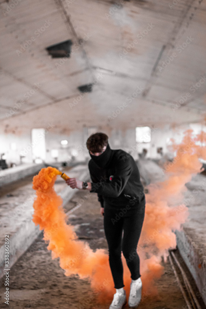 Obraz Młody człowiek z pomarańczową bombą dymną.