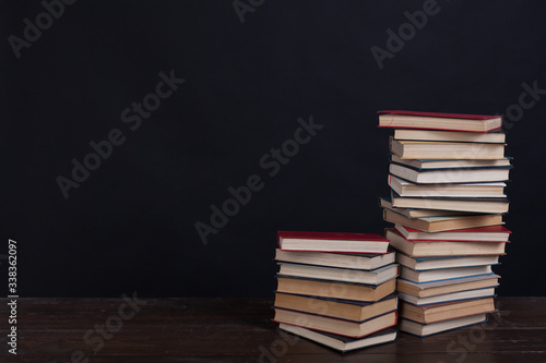 many stacks of educational books to teach in the library on a black background