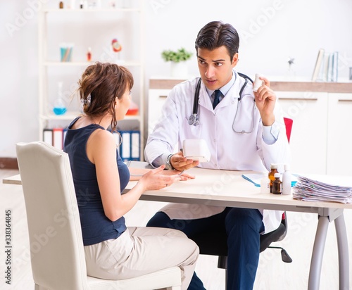 Young doctor checking woman s blood pressure