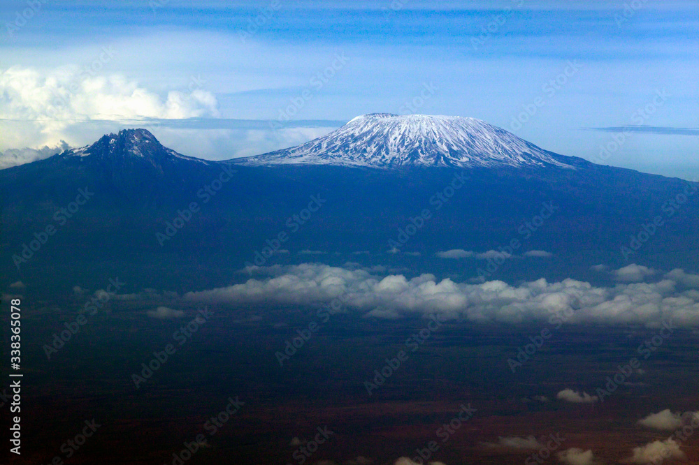 Aerial image of Mount Kilimanjaro, Africa's highest mountain, with snow and white puffy clouds from Kenya Aerial image of Mount Kilimanjaro, Africa's highest mountain, with snow and white puffy clouds from Kenya