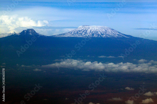 Aerial image of Mount Kilimanjaro, Africa's highest mountain, with snow and white puffy clouds from Kenya