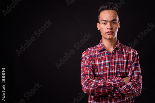 Portrait of young handsome Indian hipster man