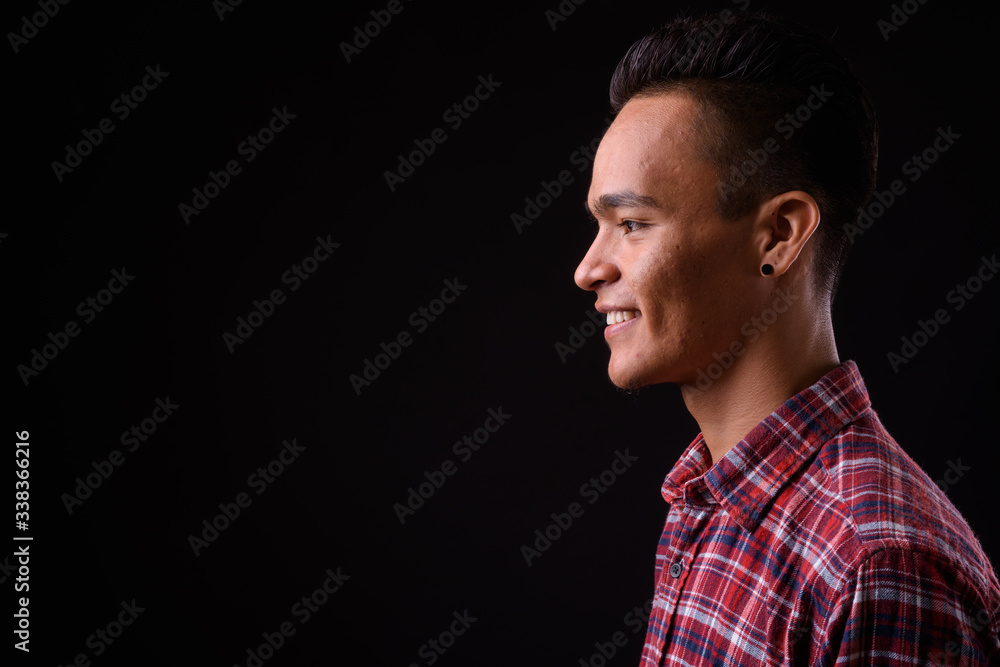 Closeup profile view of happy young Indian hipster man smiling Closeup profile view of happy young Indian hipster man smiling