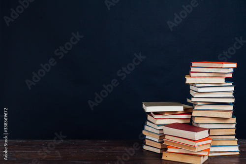 many stacks of educational books to teach in the library on a black background