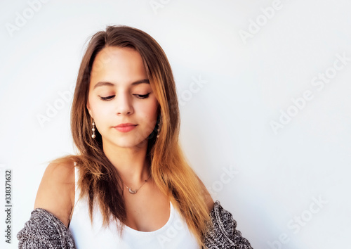 Portrait of a young beautiful girl with long dark hair looking down. Cute Youthful Teenage Female. Copy space