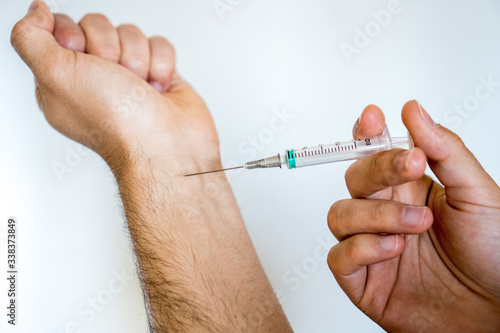 Man who is going to inject himself into the arm with a syringe