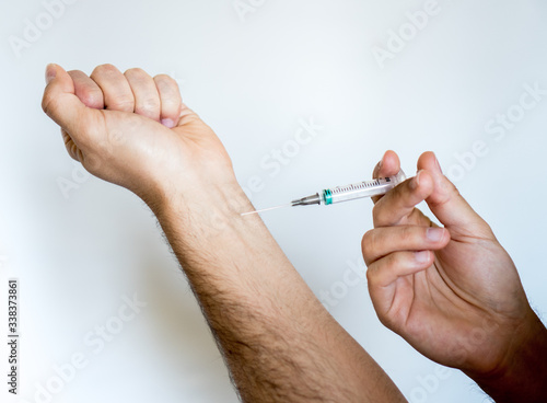 Man who is going to inject himself into the arm with a syringe