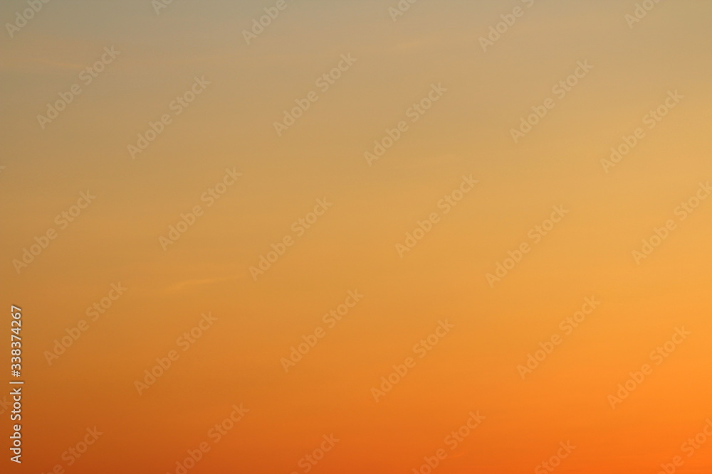 Sun below the horizon and fiery dramatic orange sky at sunset or dawn backlit by the sun. Place for text and design.