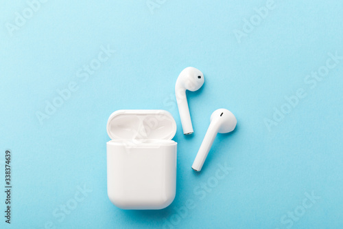 Modern wireless bluetooth headphones with charging case on a blue background.