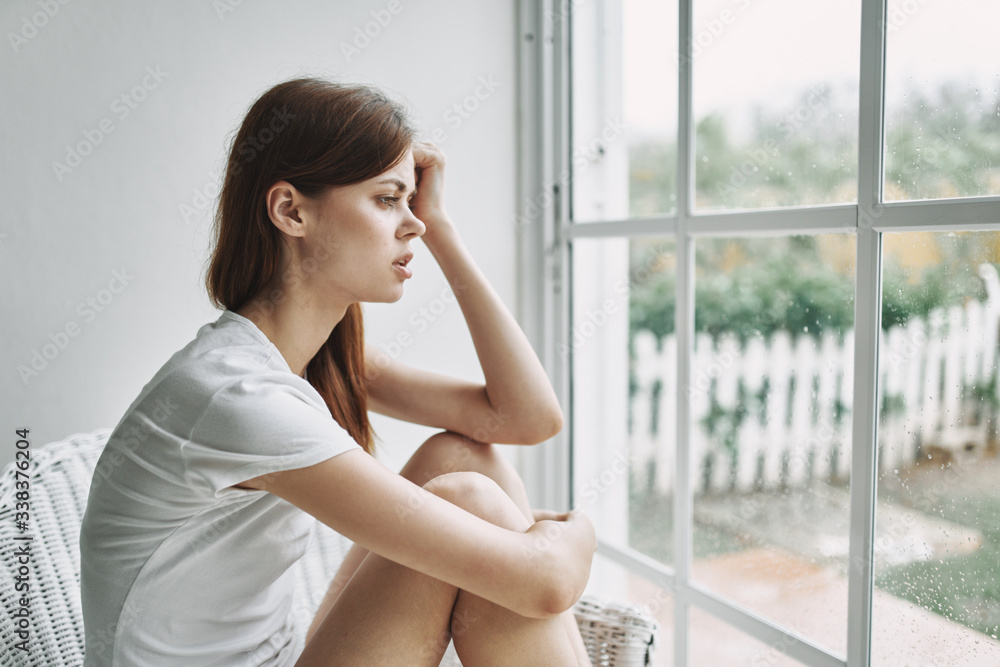 young woman looking out window