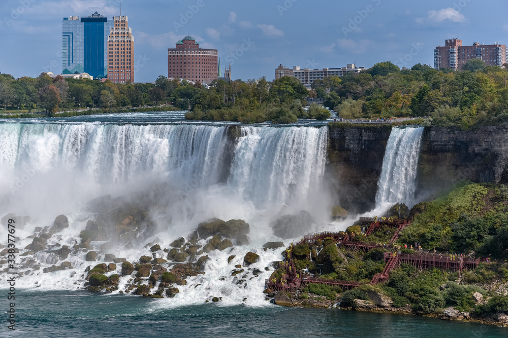 Panorama of the American side of the falls, with buildings in the background. Concept of travel and tourism. Niagara Falls, Canada. United States Panorama of the American side of the falls, with buildings in the background. Concept of travel and tourism. Niagara Falls, Canada. United States