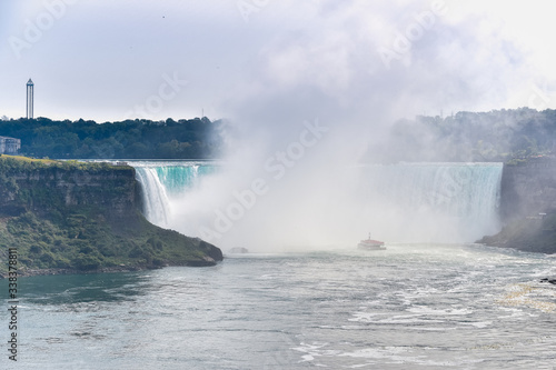 Panorama of the Canadian side of the falls  with a tourist boat. Concept of travel and tourism. Niagara Falls  Canada. United States of America