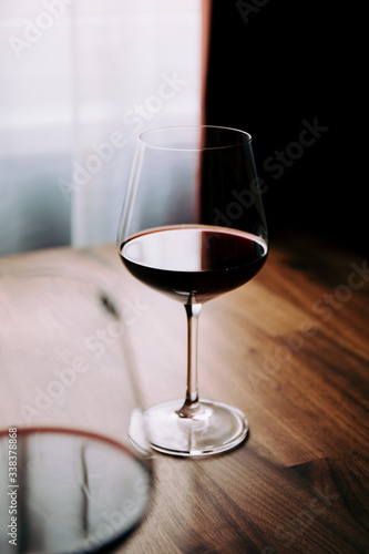 Red wine glass on a wooden table at home