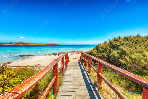 Wonderful view of Famous La Pelosa beach (Spiaggia della Pelosa) with wooden footbridge