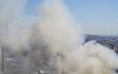 White smoke over blue sky. Fire in the city.