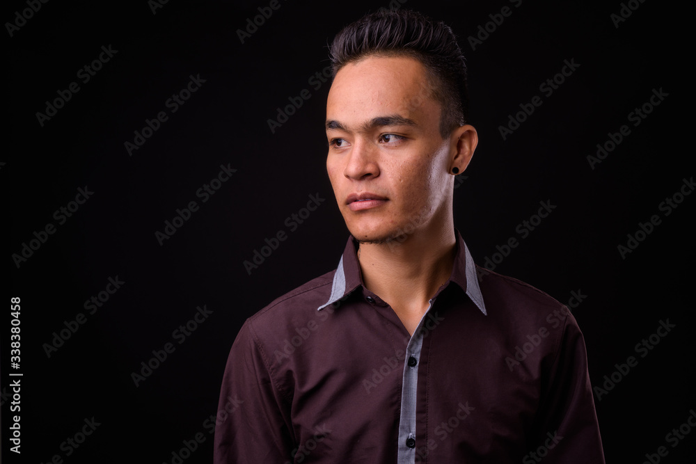 Portrait of young handsome Indian businessman thinking Portrait of young handsome Indian businessman thinking