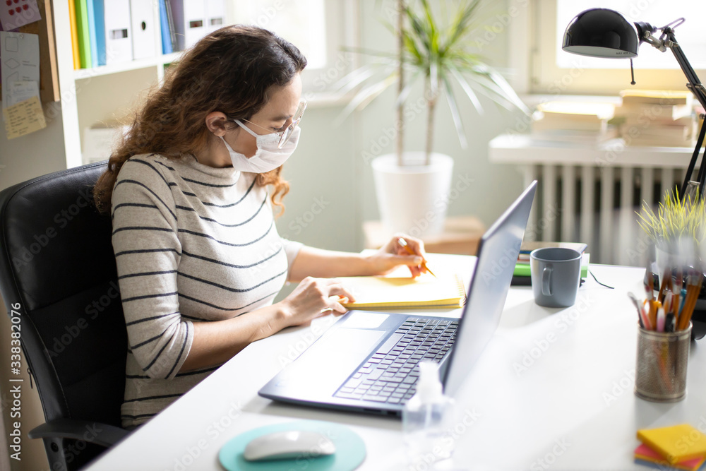 Young business woman working from home wearing protective mask Young business woman working from home wearing protective mask