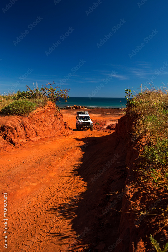 Western Australia – Outback track with 4WD car going uphill from the ocean at Dampier Peninsula Western Australia – Outback track with 4WD car going uphill from the ocean at Dampier Peninsula