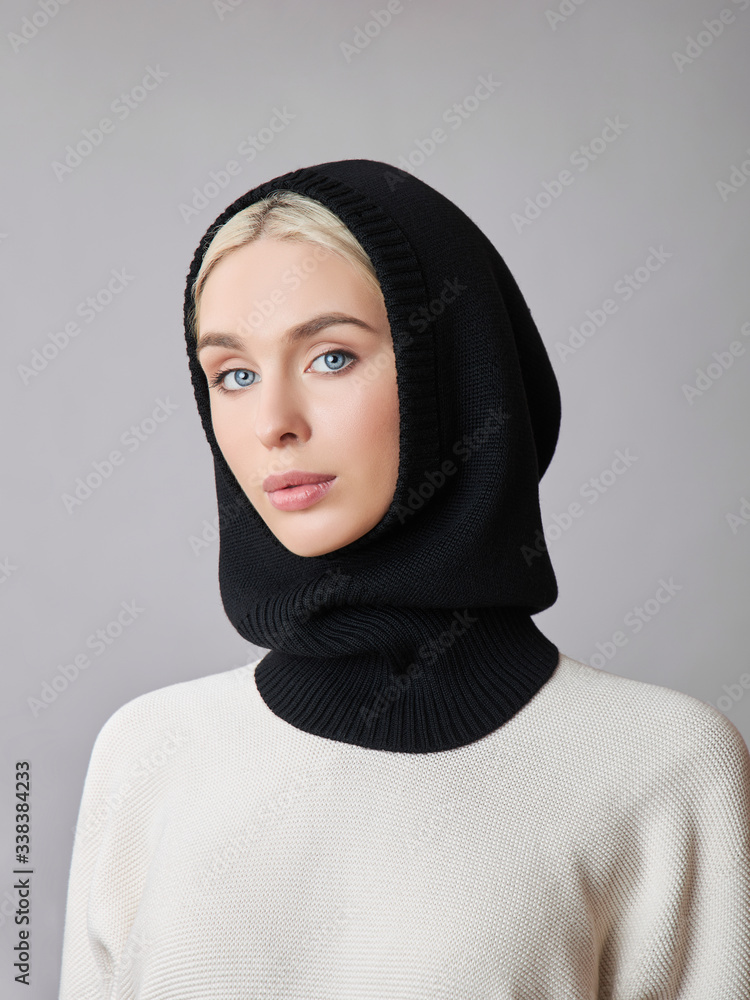 European Muslim woman with a blonde hair in a bonnet hood dressed on her head. Beautiful girl in sweater with soft skin, natural cosmetics European Muslim woman with a blonde hair in a bonnet hood dressed on her head. Beautiful girl in sweater with soft skin, natural cosmetics