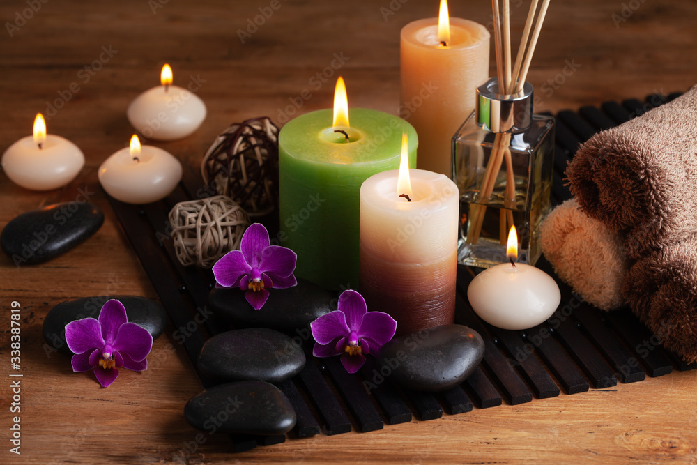 Aromatherapy, spa, beauty treatment and wellness background with massage stone, orchid flowers, towels and burning candles...