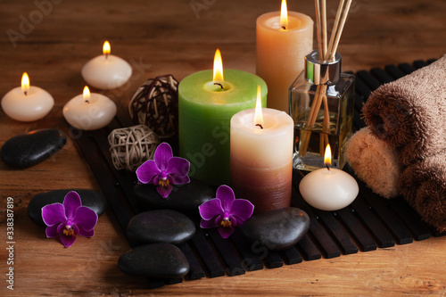 Aromatherapy  spa  beauty treatment and wellness background with massage stone  orchid flowers  towels and burning candles...