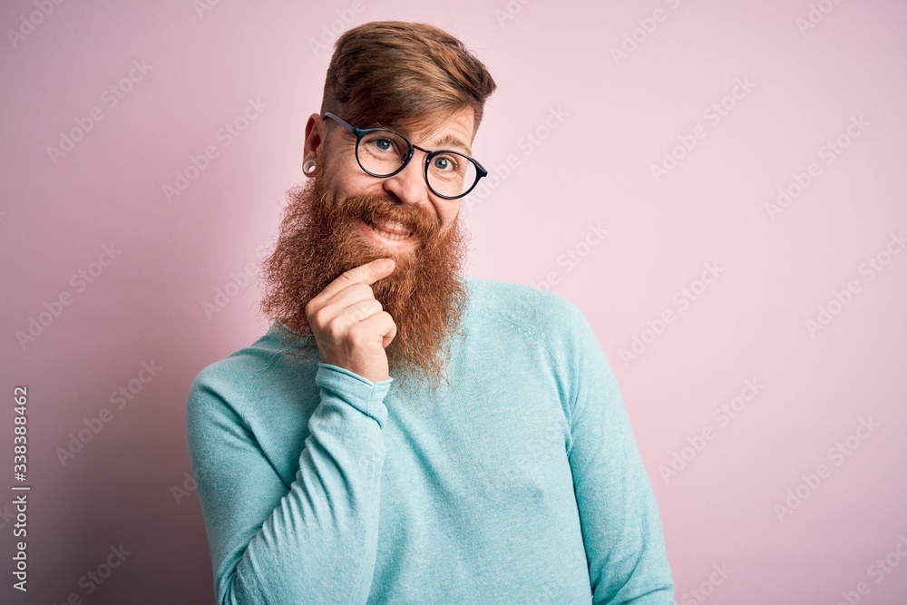 Handsome Irish redhead man with beard wearing glasses over pink isolated background looking confident at the camera smiling with crossed arms and hand raised on chin. Thinking positive. Handsome Irish redhead man with beard wearing glasses over pink isolated background looking confident at the camera smiling with crossed arms and hand raised on chin. Thinking positive.