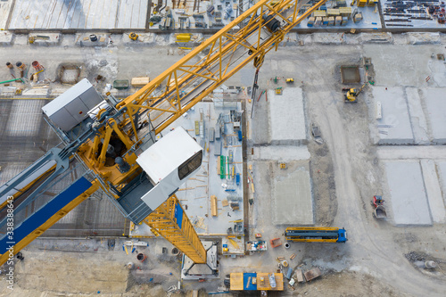 big yellow crane on construction building site with aerial view from top