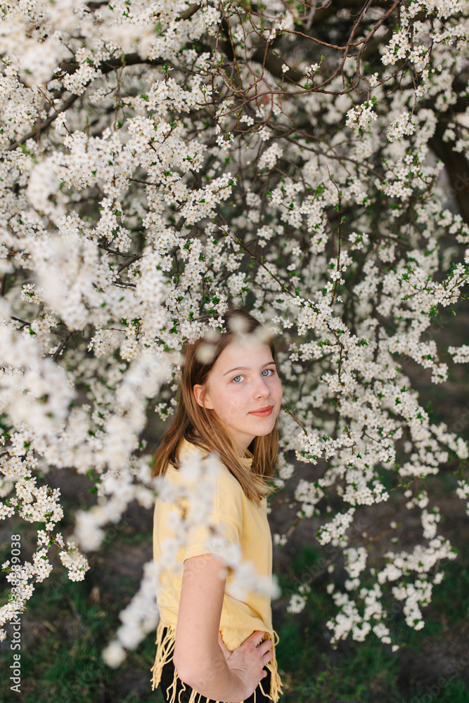portrait of sad young woman in protective medical face mask with flowers near blooming tree in spring time. Coronavirus protection. epidemic of coronavirus. the aroma a tree in the garden on a spring portrait of sad young woman in protective medical face mask with flowers near blooming tree in spring time. Coronavirus protection. epidemic of coronavirus. the aroma a tree in the garden on a spring