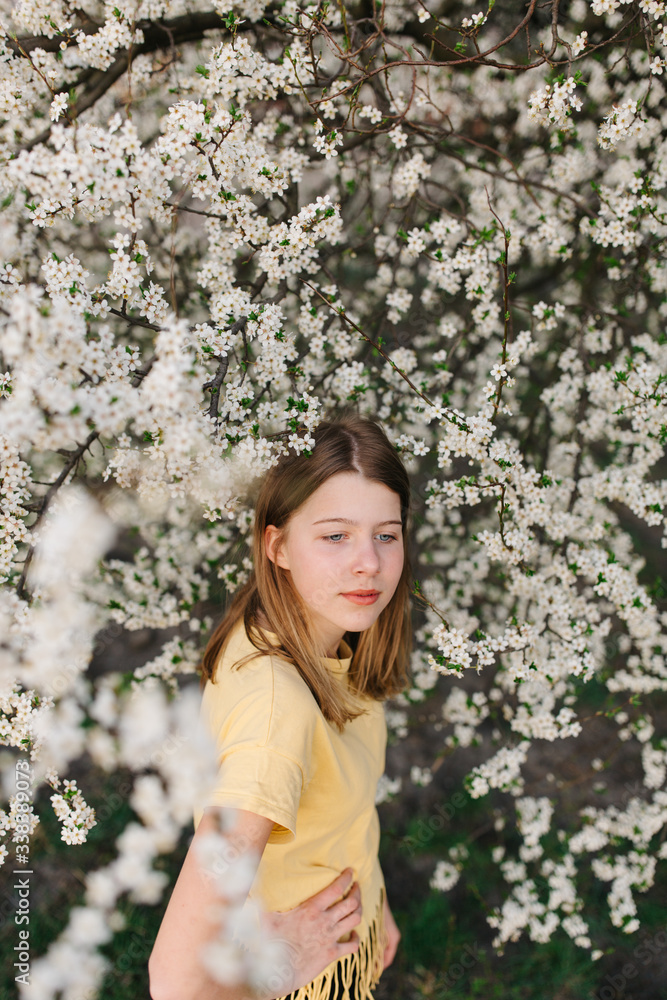 portrait of sad young woman in protective medical face mask with flowers near blooming tree in spring time. Coronavirus protection. epidemic of coronavirus. the aroma a tree in the garden on a spring portrait of sad young woman in protective medical face mask with flowers near blooming tree in spring time. Coronavirus protection. epidemic of coronavirus. the aroma a tree in the garden on a spring
