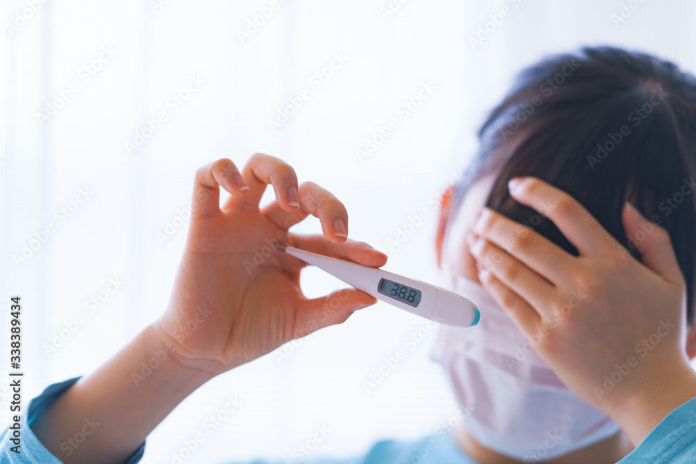Japanese woman measures fever with thermometer Japanese woman measures fever with thermometer