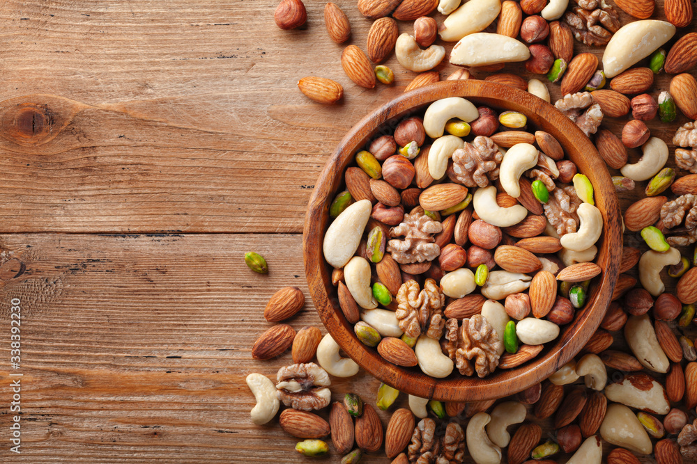 Wooden bowl with mixed nuts on rustic table top view. Healthy food and snack. Wooden bowl with mixed nuts on rustic table top view. Healthy food and snack.