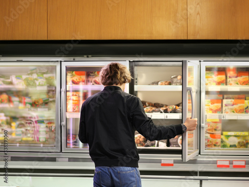 Man choosing frozen food from a supermarket freezer 