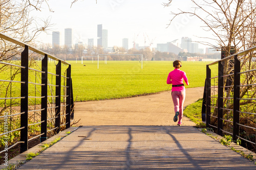Fotografia Social distancing - jogging alone in the park near Hackney Marshes, London