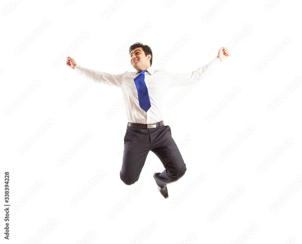 Young office corporate man jumping high spreading his arms with joy wearing blue tie isolated on a white background